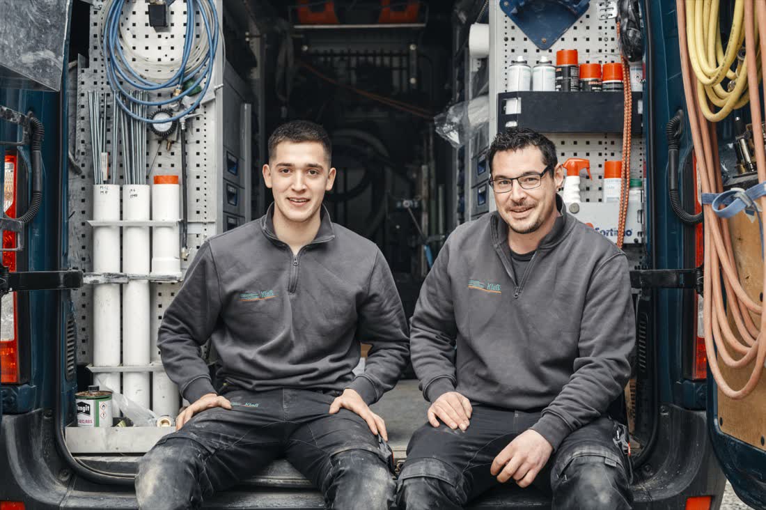 SHK-Team vor dem Firmenfahrzeug