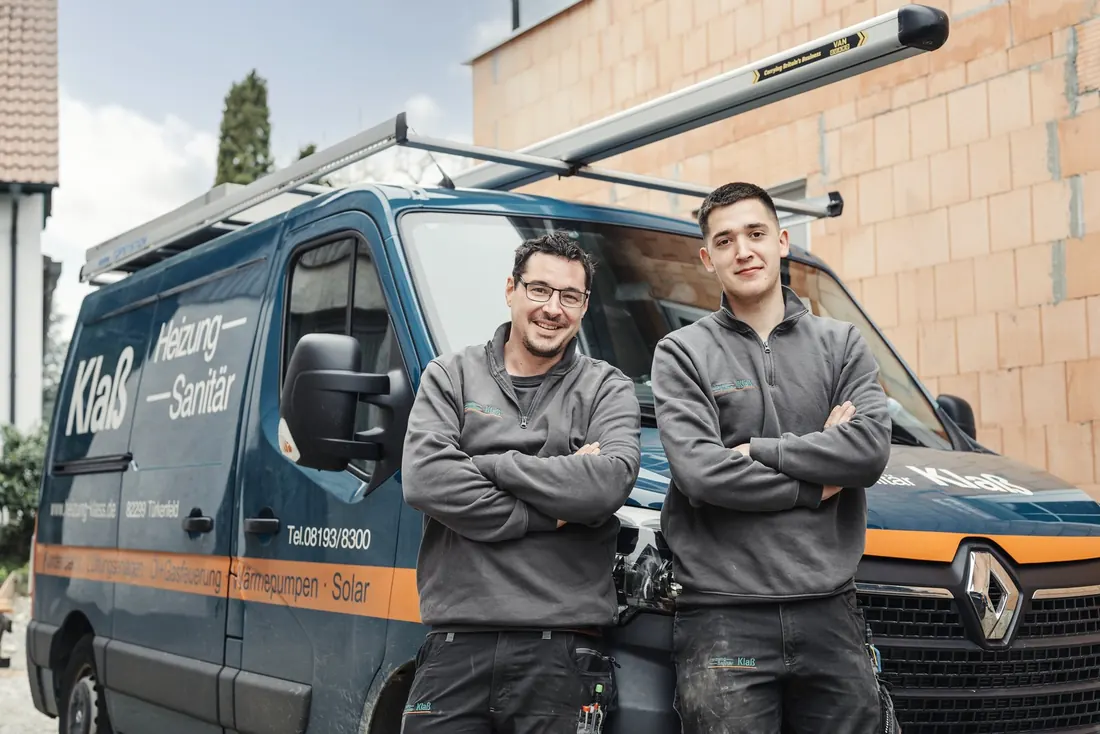 Zwei Monteure von Heizung-Sanitär Klaß mit verschränkten Armen vor dem Firmenwagen