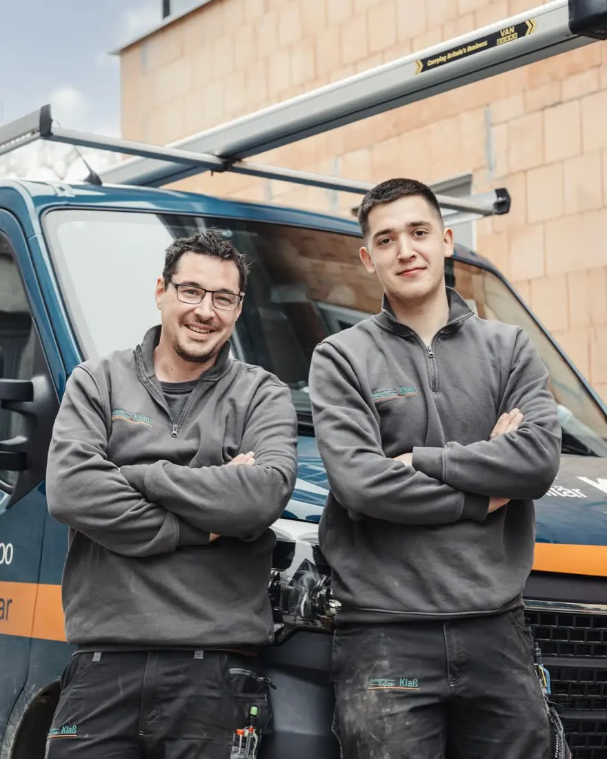 Zwei Monteure von Heizung-Sanitär Klaß am Firmenwagen