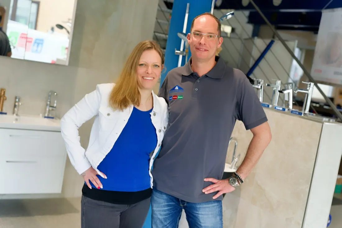 Frau und Mann in der Badausstellung eines SHK-Betriebs, zwischen Waschtischen und Armaturen